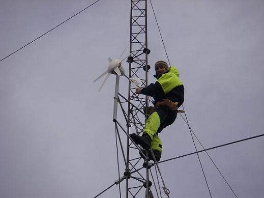TC climbs the mast to install the wind generator