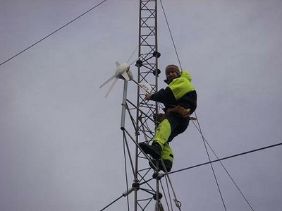 TC climbs the mast to install the wind generator